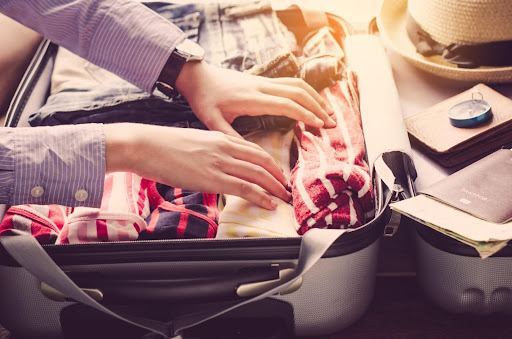 A picture of a person packing a suitcase.